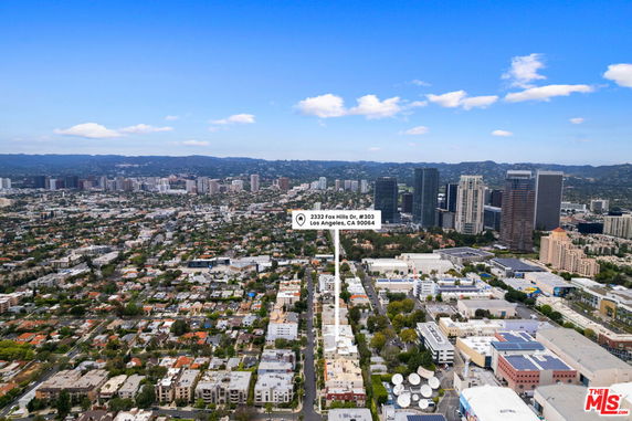 Panoramic view of a city with various buildings and a skyline in the background.