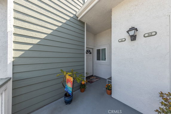 Entrance area of a residential building with a white door and numbered signs.
