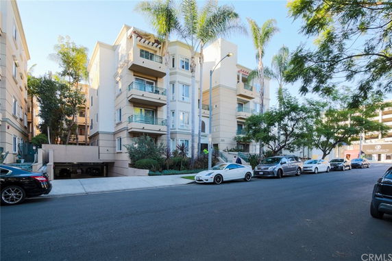 Front view of a multi-story apartment building with balconies.