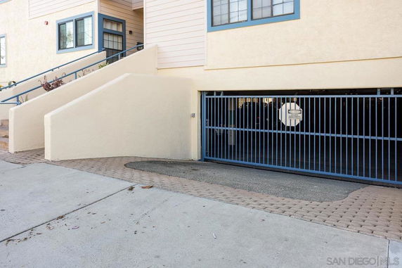 Covered parking area with a gated entrance in a residential building.