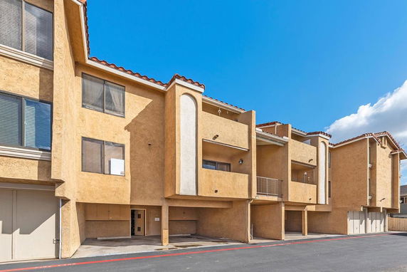 Front view of a multistory building with balconies and garages.