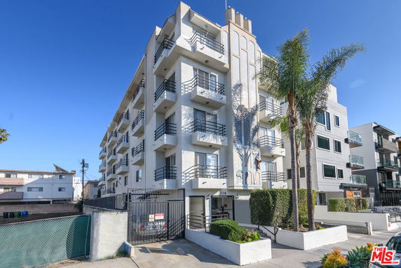 Front view of a multi-story apartment building with balconies.