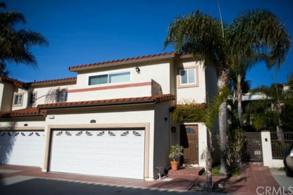 Front view of a two-story house with a double garage and a tiled roof.