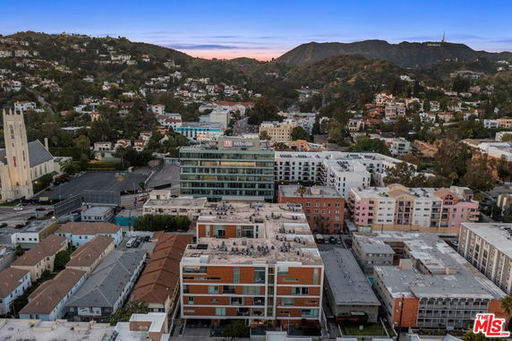 Aerial view of a cityscape with buildings and hills in the background.