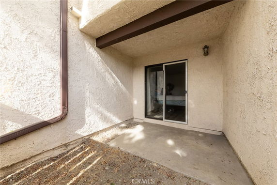 Outdoor area with sliding glass door and overhang.