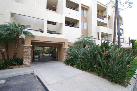 Front view of a multi-story residential building with balconies.
