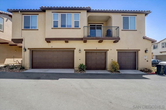 Front view of a two-story house with three garage doors.