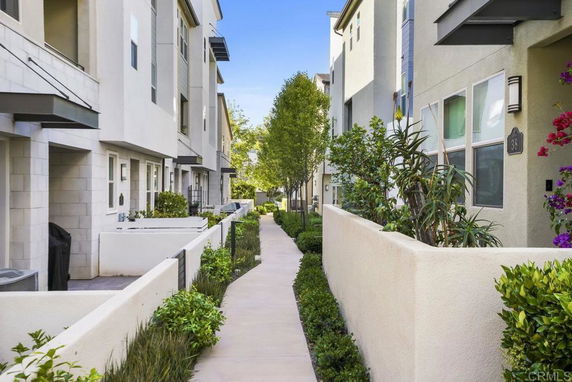 Pathway between residential buildings with modern architecture.