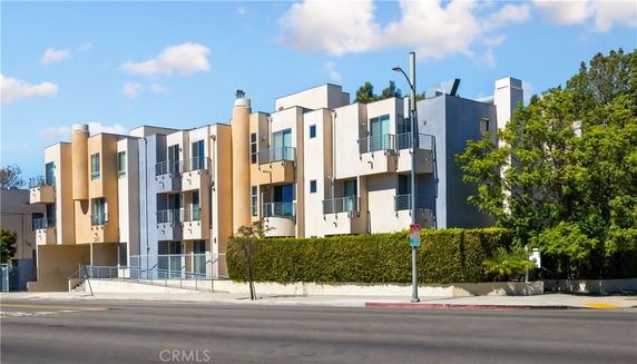 Front view of a multi-story modern apartment building with balconies.