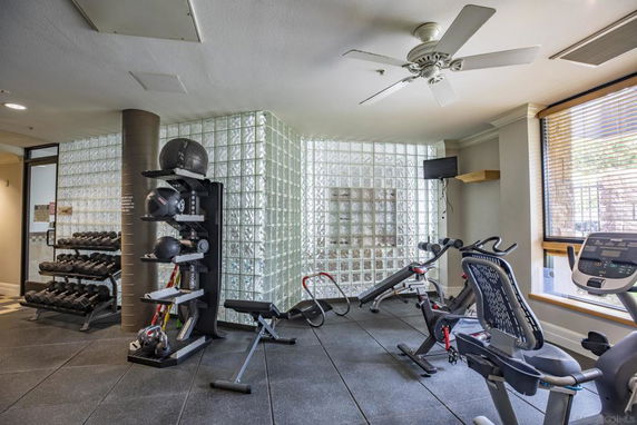 Indoor gym area with exercise equipment including weights and machines.