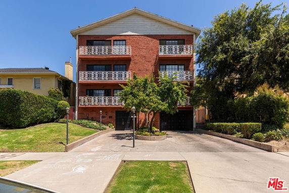 Front view of a multi-story brick building with balconies.