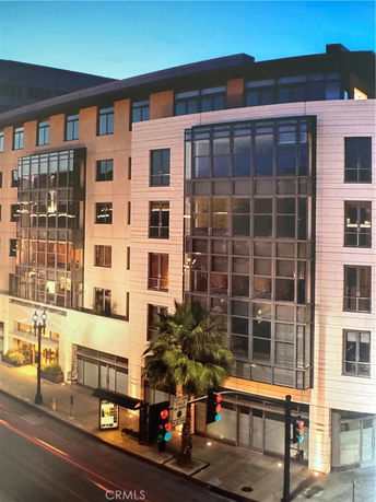 Front view of a multi-story building with large windows and street-level storefronts.