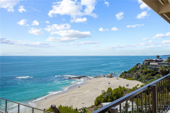 Panoramic view of the coastline from a building with a beach, ocean, and distant houses in sight.