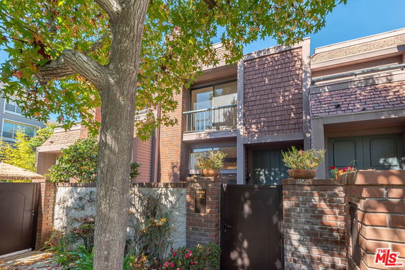 Front view of a two-story house with brick and wooden exterior.