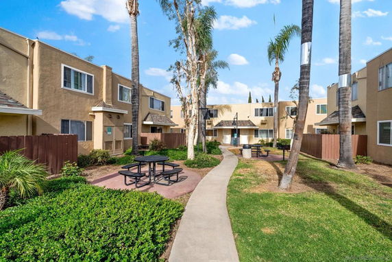 Outdoor view of a residential complex with walkways and picnic tables.