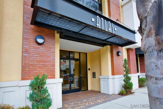 Entrance of a modern building with brick and light-colored walls.