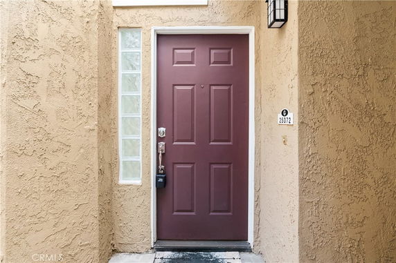 Front view of a house entrance with a brown door and adjacent glass blocks.