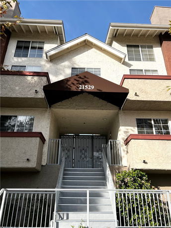 Front view of a multi-story building with a staircase and entrance canopy.
