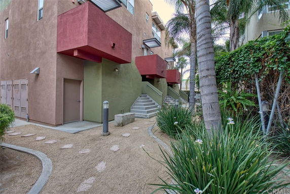 Front view of a modern apartment building with multiple levels and colorful balconies.