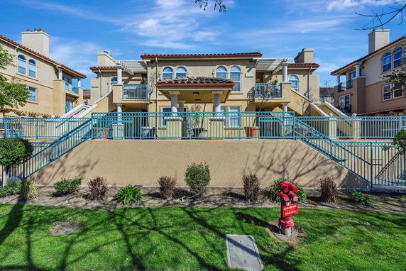 Front view of a multi-story residential building with staircases and balconies.