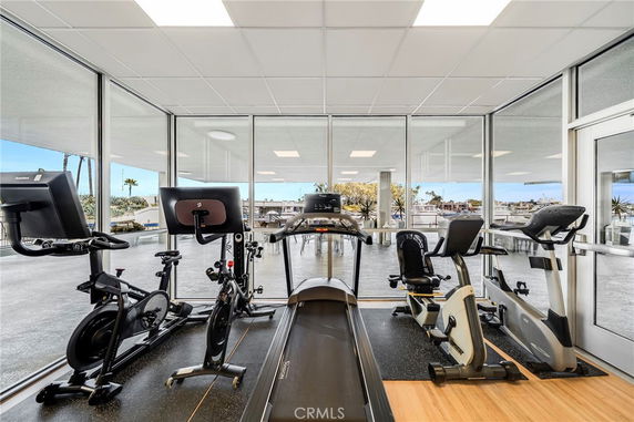 Indoor gym area with exercise equipment including treadmills and bikes.