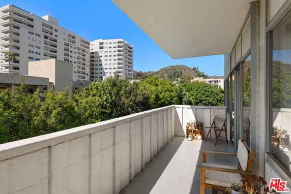 View from a balcony overlooking nearby buildings and greenery.