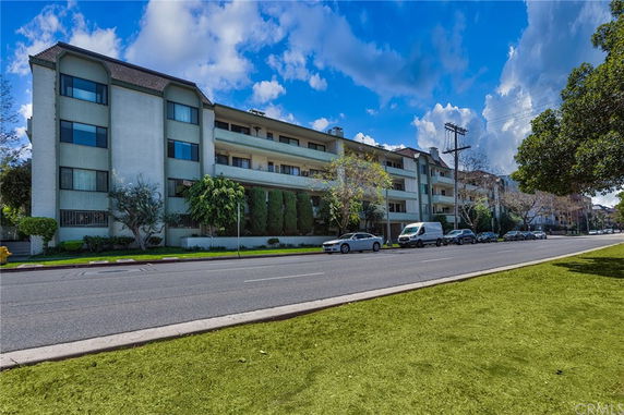 Front view of a multi-story apartment building with balconies.