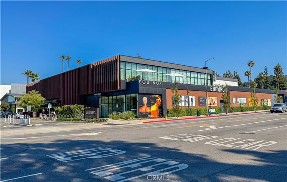 Front view of a modern commercial building with large glass windows and signage.