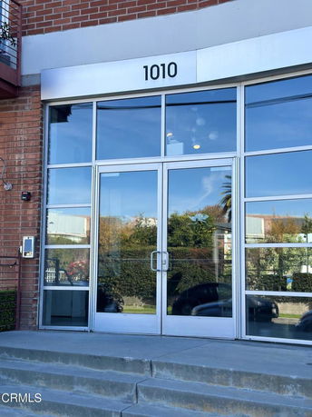 Front view of a glass entrance with a numeric sign on top.