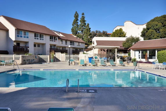 Outdoor area with a swimming pool in front of residential buildings.