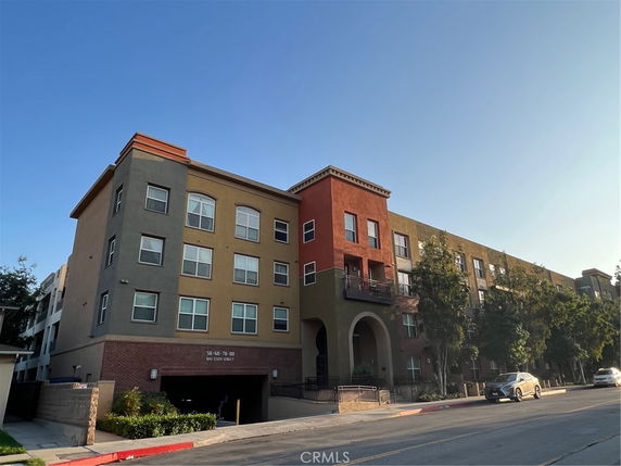 Front view of a multi-story apartment building with a red and beige facade.