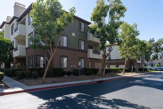 Front view of a multi-story residential building with balconies and garage.