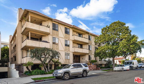 Front view of a multi-story apartment building with balconies.