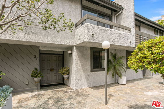 Front view of a two-story building with a balcony and double front doors.