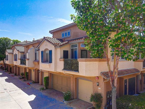 Front view of multiple two-story townhouses with garages.