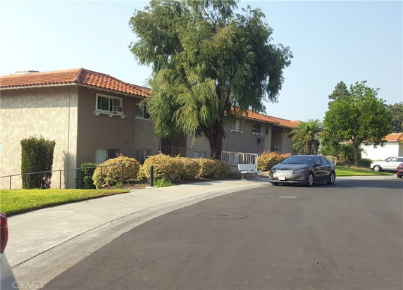 Front view of a two-story building with a tiled roof and a driveway.