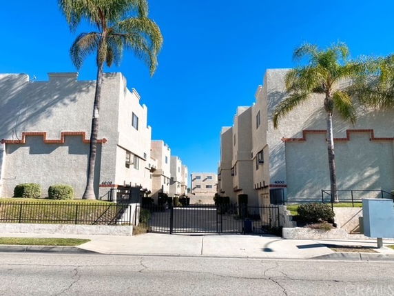 Front view of a residential apartment building with a gated entrance.