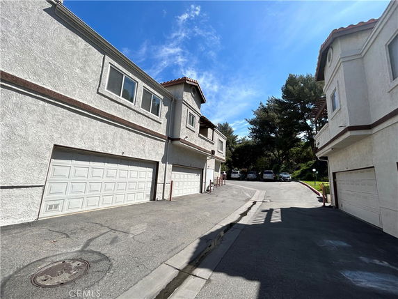 Outdoor parking area with garages beneath residential buildings