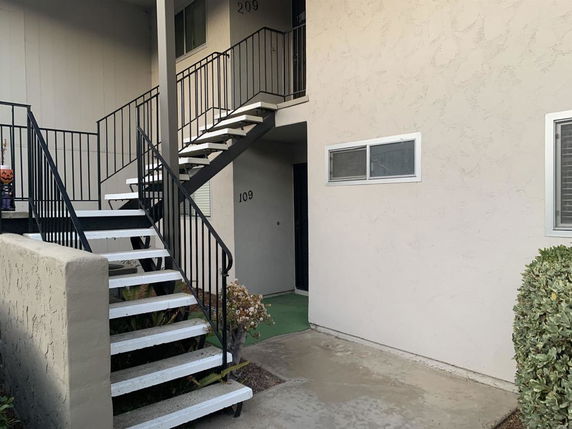 Front view of a building with exterior stairs leading to upper level units.
