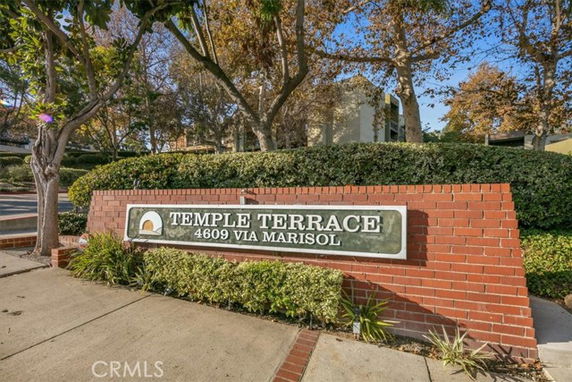 Front view of a brick sign for Temple Terrace at 4609 Via Marisol, with greenery and trees surrounding.
