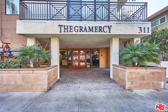 Front view of a building named 'The Gramercy' with a covered entrance and balcony above.