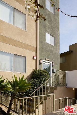 Front view of a multi-story building with stairs leading to the entrance.