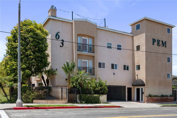 Front view of a multi-story building with balconies and multiple windows.