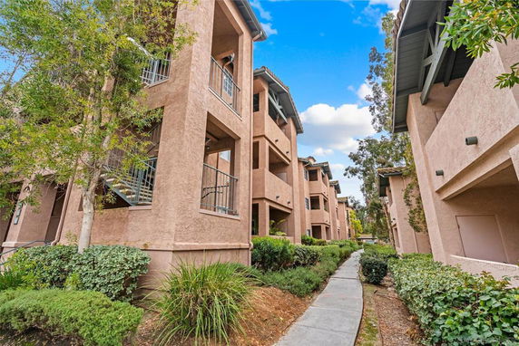 Front view of a multi-story apartment building with external staircases and balconies.
