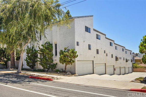 Front view of a multi-story apartment building with garages.
