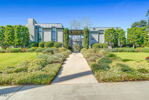 Front view of a modern two-story house with tall windows and a landscaped yard.