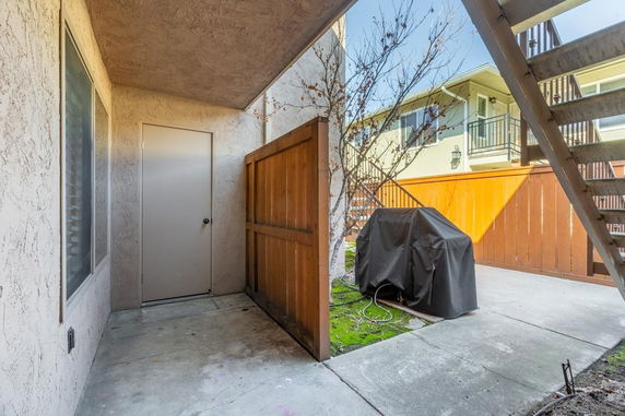 Outdoor area with a covered grill and nearby staircase.