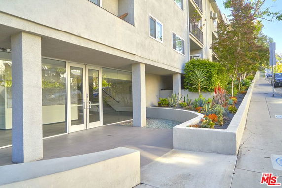 Front view of a multi-story building with a modern entrance and landscaped area.