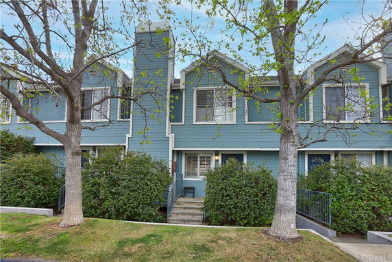 Front view of a two-story townhouse with blue siding and white trim.