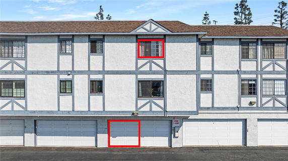 Front view of a multi-story building with garage doors on the ground level.